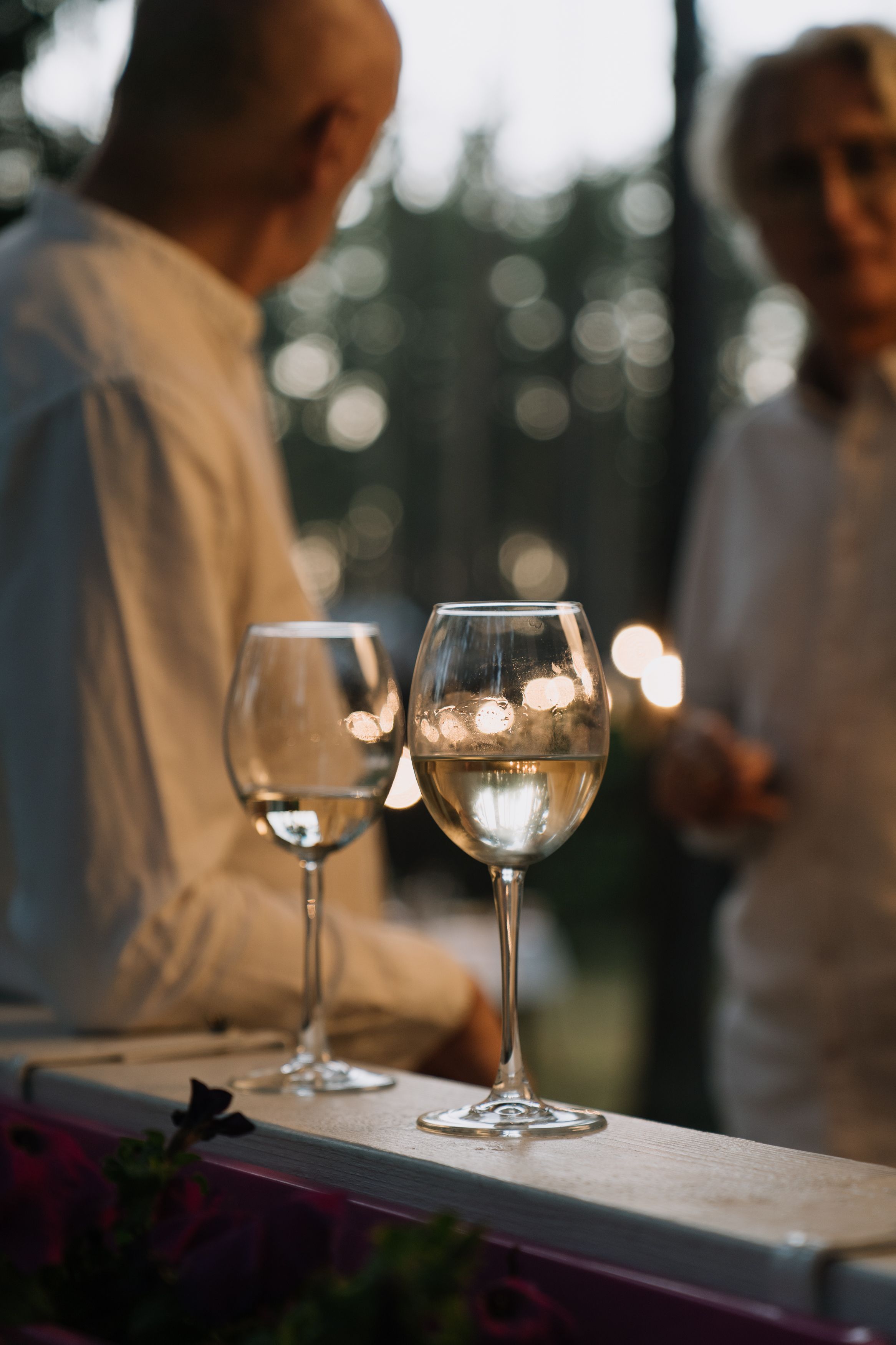 Dois copos de vinho branco num convívio ao entardecer